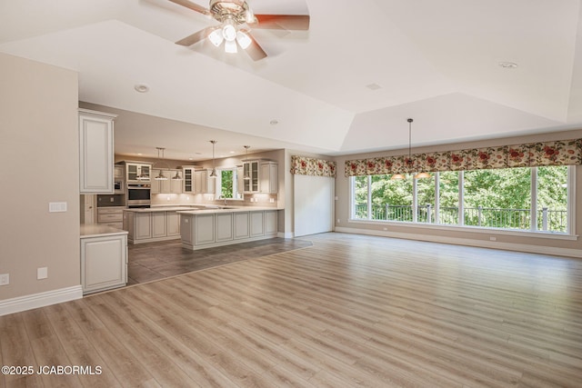 4205 Grant Ln, Columbia, MO 65203 - unfurnished living room with light wood finished floors, a raised ceiling, a ceiling fan, and recessed lighting