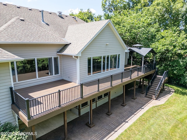 4205 Grant Ln, Columbia, MO 65203 - rear view of house featuring a deck, roof with shingles, stairway, a patio, and a lawn