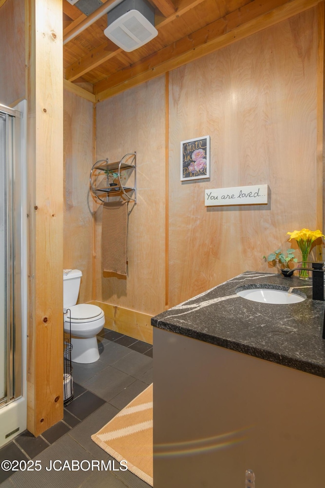 full bath with toilet, tile patterned flooring, wood walls, and a shower with door