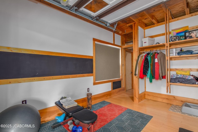 workout area with a garage and wood finished floors