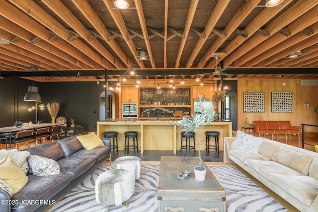 living area featuring visible vents, arched walkways, and indoor bar