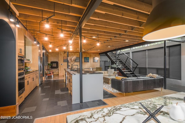 basement featuring freestanding refrigerator and stairs