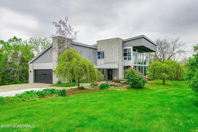 contemporary house with driveway, a front yard, and an attached garage