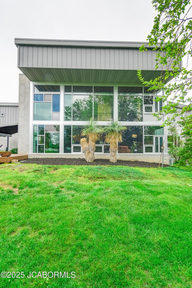 rear view of house featuring a lawn