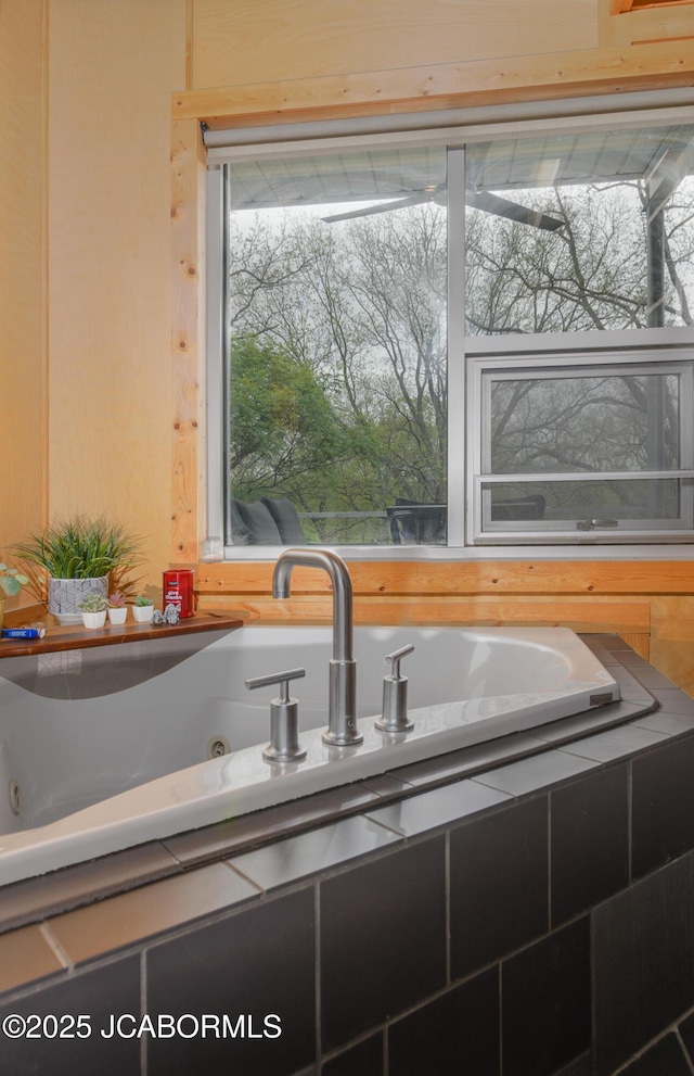 interior space featuring a tub with jets and a sink