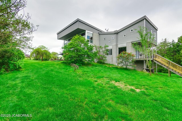 rear view of house with a yard and stairs