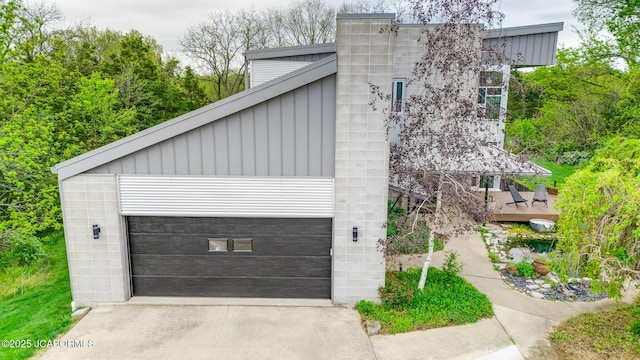 view of side of property with a garage, board and batten siding, and driveway