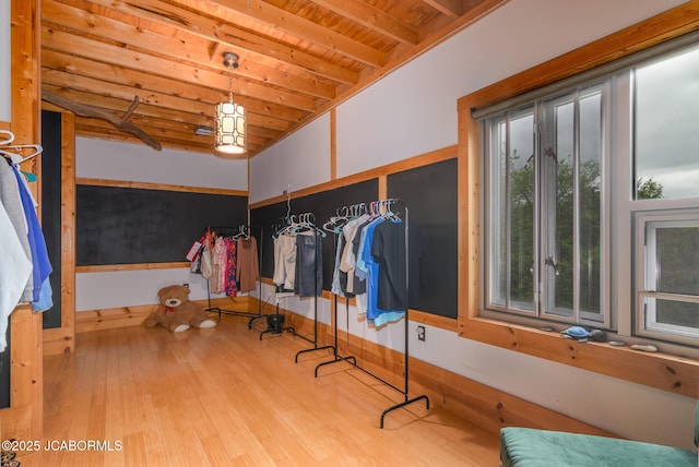 walk in closet featuring beam ceiling and wood finished floors