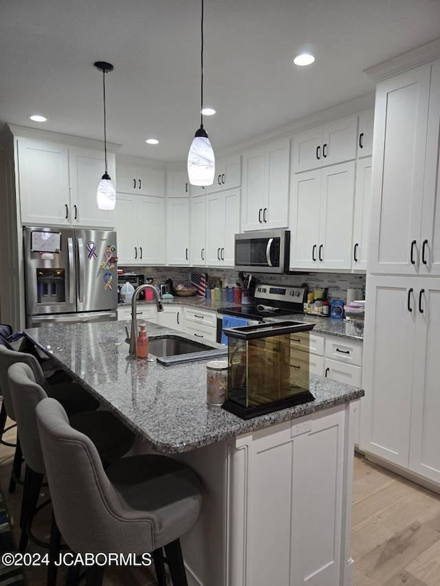 kitchen featuring stainless steel appliances, white cabinets, and sink