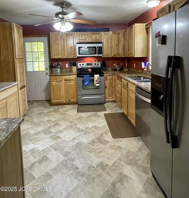 909 E Jefferson St, Linn, MO 65051 - kitchen featuring appliances with stainless steel finishes, dark stone countertops, a sink, and ceiling fan