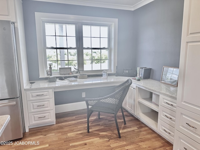 office area with ornamental molding, light wood finished floors, and built in study area