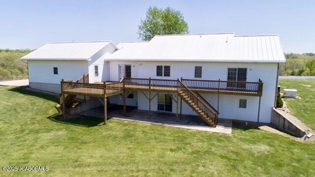 back of property with a lawn, stairs, and a deck