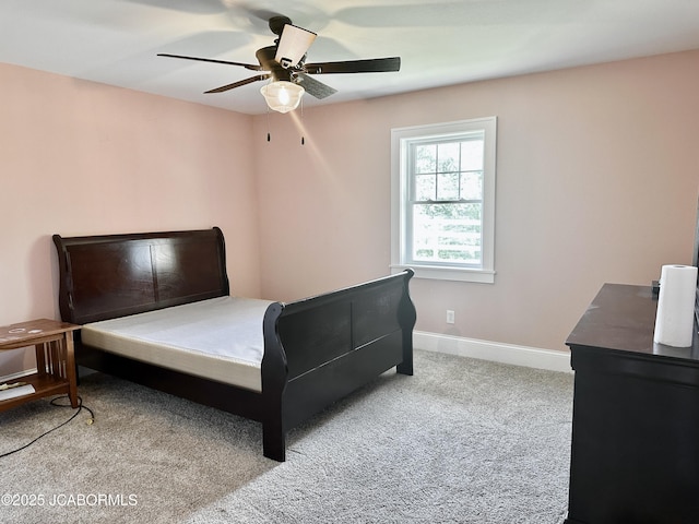 bedroom featuring light colored carpet, baseboards, and ceiling fan