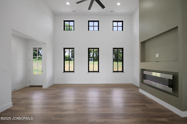 5306 Tebbetts View Dr, Tebbetts, MO 65080 - unfurnished living room with ceiling fan, plenty of natural light, a glass covered fireplace, a towering ceiling, and recessed lighting