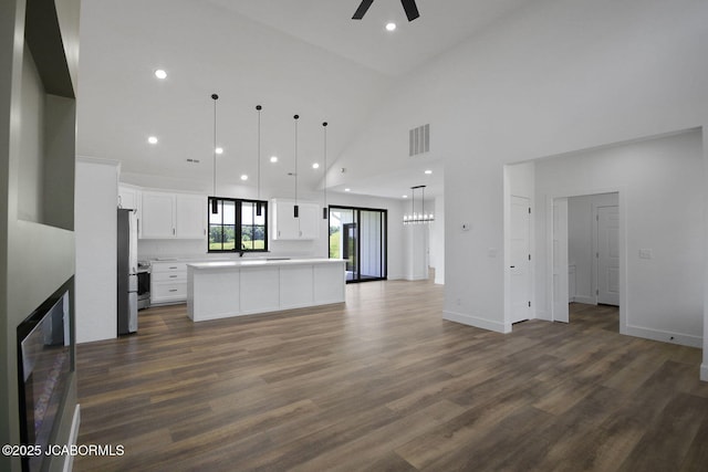 5306 Tebbetts View Dr, Tebbetts, MO 65080 - unfurnished living room featuring ceiling fan, high vaulted ceiling, dark wood-type flooring, recessed lighting, and a chandelier