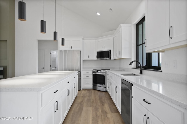 5306 Tebbetts View Dr, Tebbetts, MO 65080 - kitchen with stainless steel appliances, a center island, wood finished floors, white cabinetry, and pendant lighting