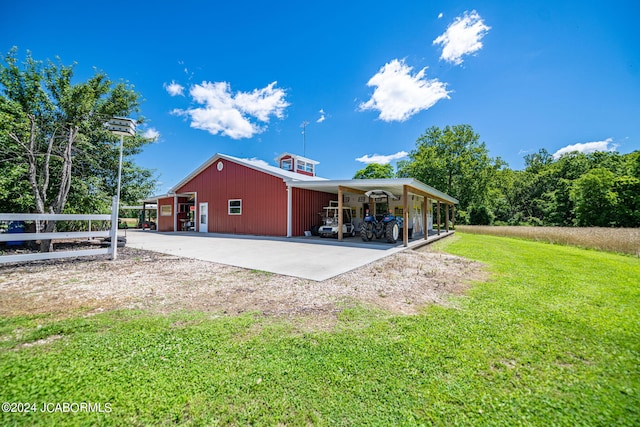 back of house featuring a lawn and an outbuilding