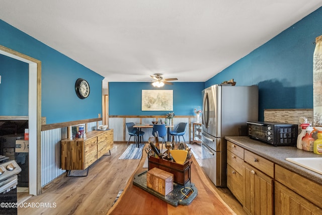 6733 Rocking Horse Ln, Fulton, MO 65251 - kitchen featuring freestanding refrigerator, a ceiling fan, light wood-type flooring, a wainscoted wall, and a sink