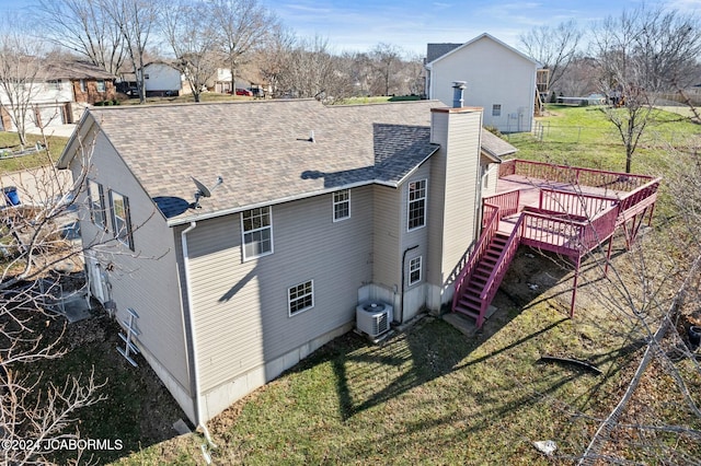 back of property with a yard and a wooden deck