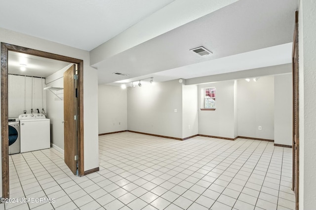 basement with light tile patterned floors and separate washer and dryer