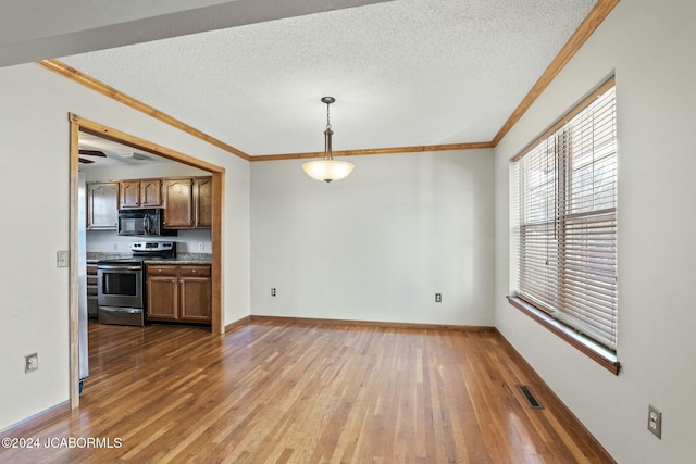 interior space with stainless steel electric stove, ornamental molding, pendant lighting, and wood-type flooring