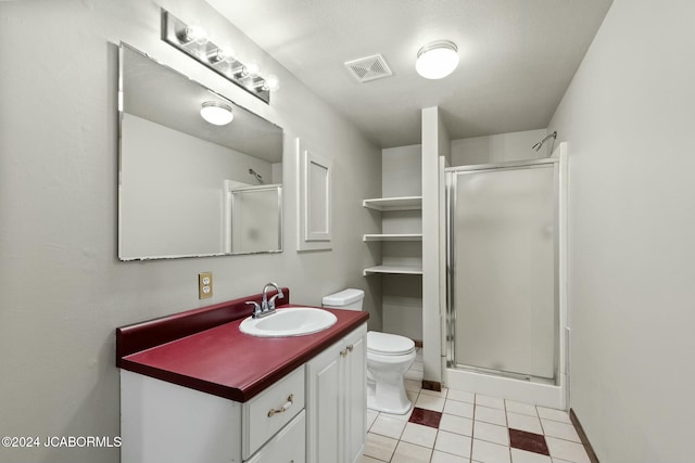 bathroom with tile patterned flooring, vanity, an enclosed shower, and toilet