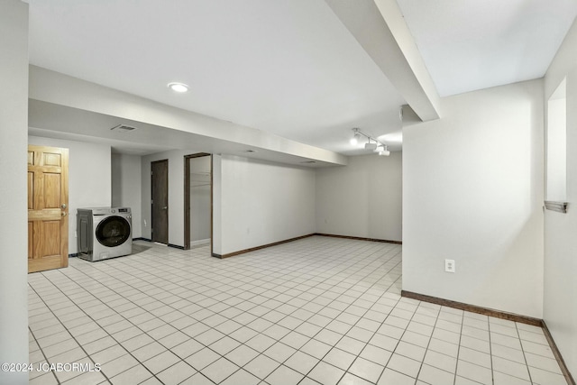 basement featuring light tile patterned floors and washer / clothes dryer