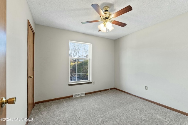 empty room featuring ceiling fan, carpet floors, and a textured ceiling