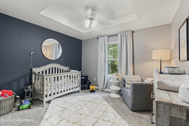 1330 Summerfield Dr, Jefferson City, MO 65109 - carpeted bedroom with a crib, a raised ceiling, and a ceiling fan