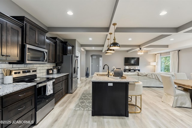 1330 Summerfield Dr, Jefferson City, MO 65109 - kitchen featuring stainless steel appliances, open floor plan, light wood-style floors, a center island with sink, and ceiling fan