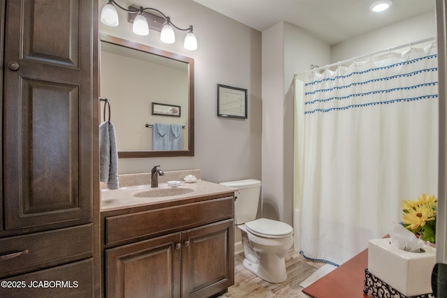 bathroom with a shower with curtain, vanity, hardwood / wood-style floors, and toilet