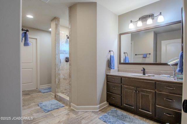 bathroom with vanity, hardwood / wood-style floors, and a tile shower