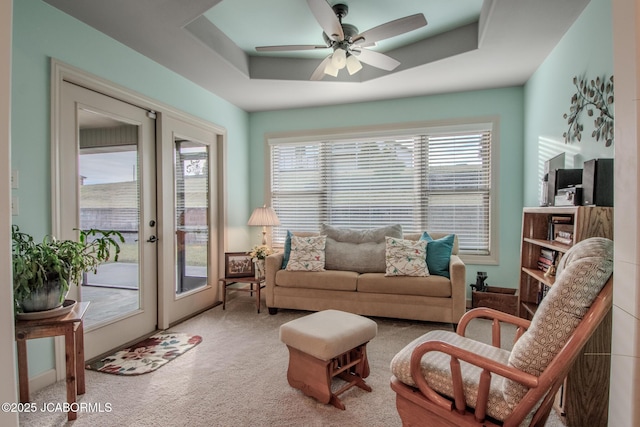 living room featuring french doors, carpet, ceiling fan, and a tray ceiling