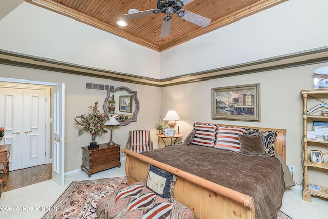 bedroom featuring ceiling fan, light colored carpet, wooden ceiling, and crown molding