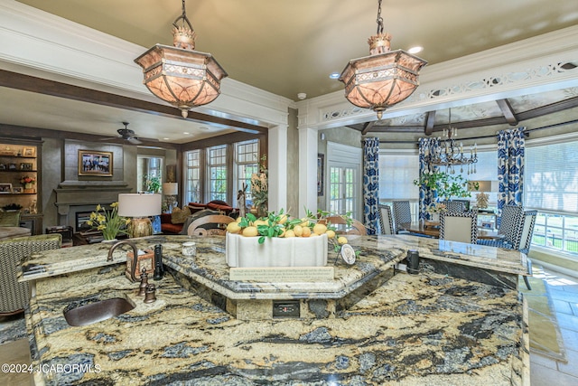 dining space featuring wooden walls, ceiling fan, ornamental molding, and sink