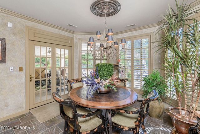 dining space with a chandelier, crown molding, and french doors