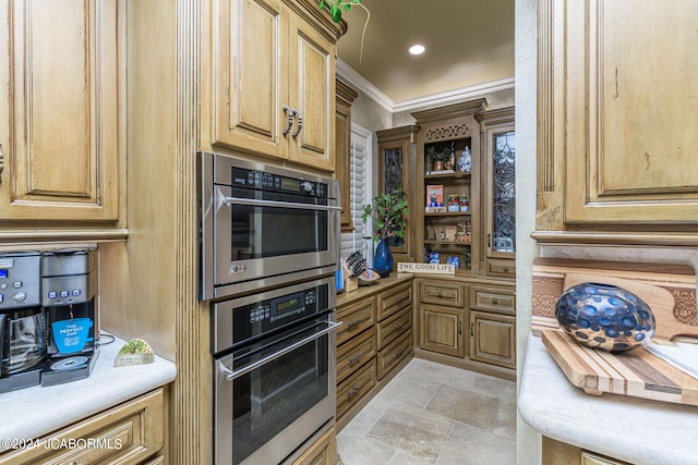 kitchen with stainless steel double oven and crown molding