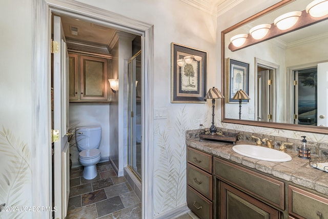 bathroom featuring vanity, toilet, a shower with shower door, and ornamental molding