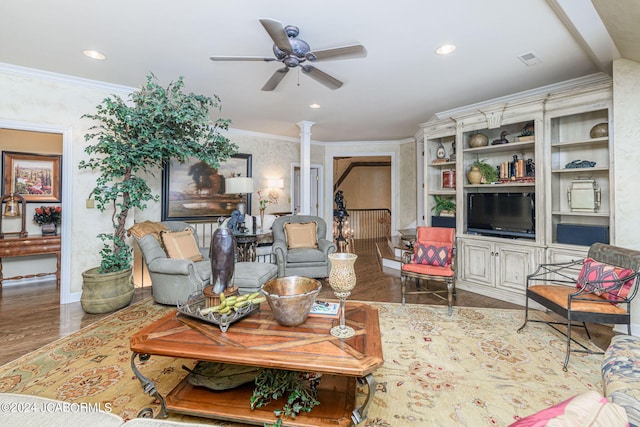 living room featuring hardwood / wood-style flooring, ceiling fan, ornate columns, and crown molding