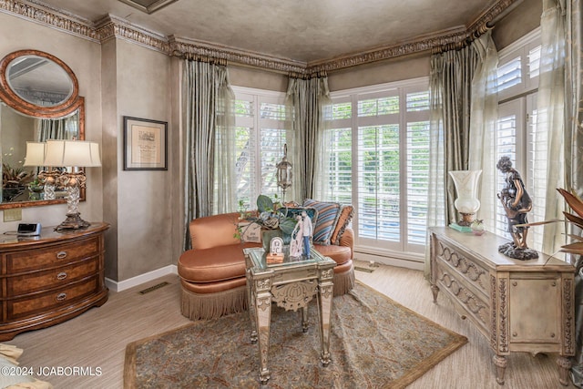 sitting room with crown molding, a wealth of natural light, and light hardwood / wood-style flooring