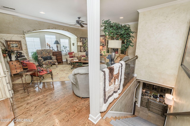 living room with light hardwood / wood-style flooring, ceiling fan, and ornamental molding