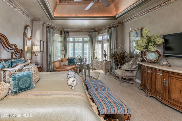 bedroom with light carpet, a tray ceiling, ceiling fan, and ornamental molding