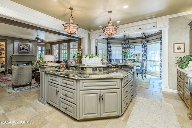 kitchen featuring pendant lighting, stone counters, a spacious island, ceiling fan, and gray cabinets