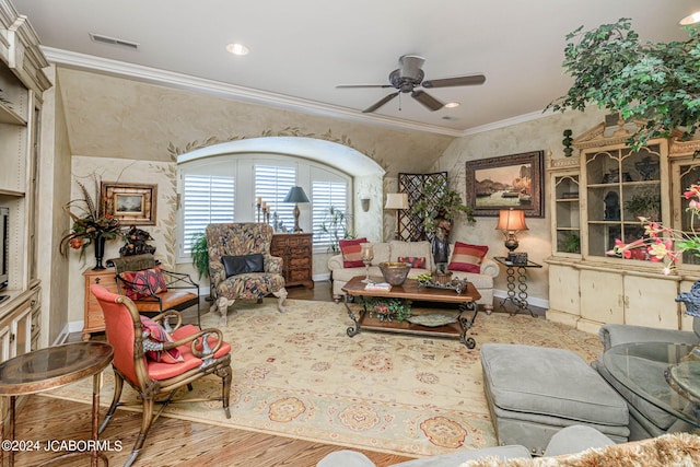 living room with ceiling fan, light wood-type flooring, and ornamental molding