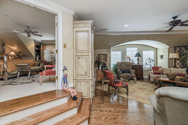 living room featuring dark hardwood / wood-style flooring, ceiling fan, and ornamental molding