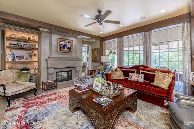 living room featuring a large fireplace and ceiling fan