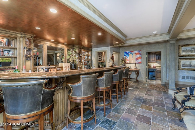 bar with wine cooler and crown molding