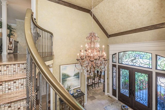 entryway featuring french doors, high vaulted ceiling, ornamental molding, and a notable chandelier