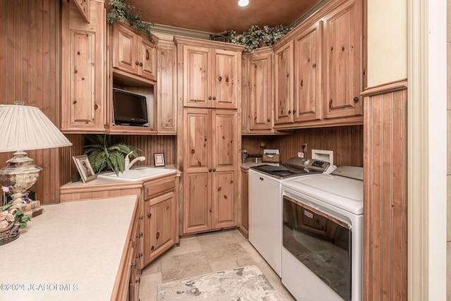 washroom featuring cabinets, washing machine and dryer, and sink