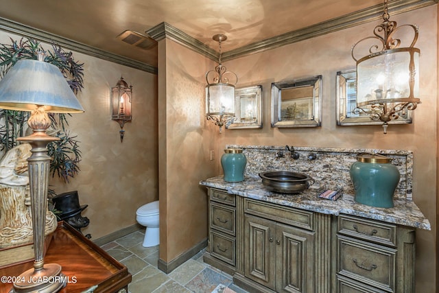 bathroom with vanity, toilet, and ornamental molding